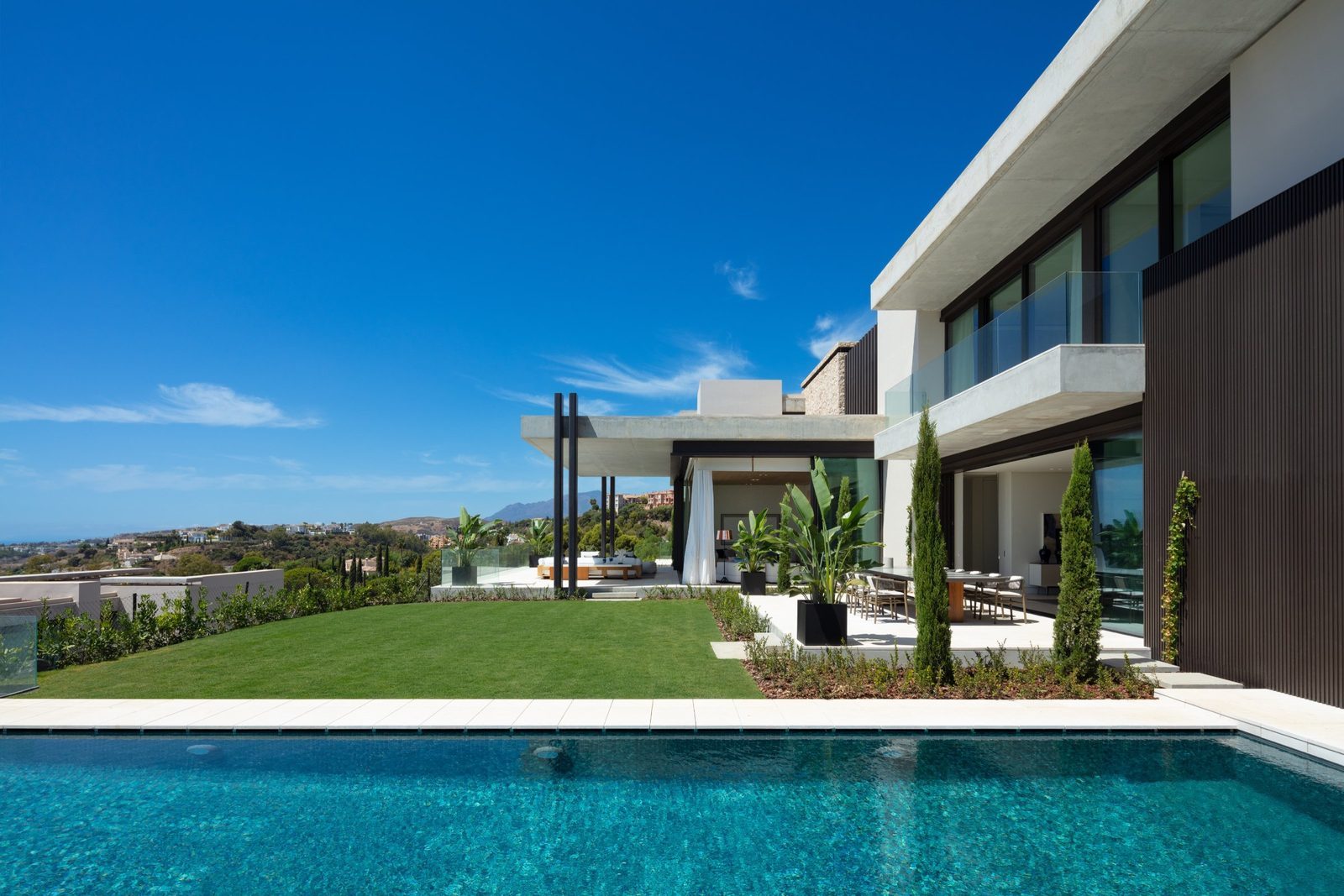 Modern villa exterior with pool, landscaped garden and panoramic sea views of a 7-bedroom villa in Málaga - The Estates