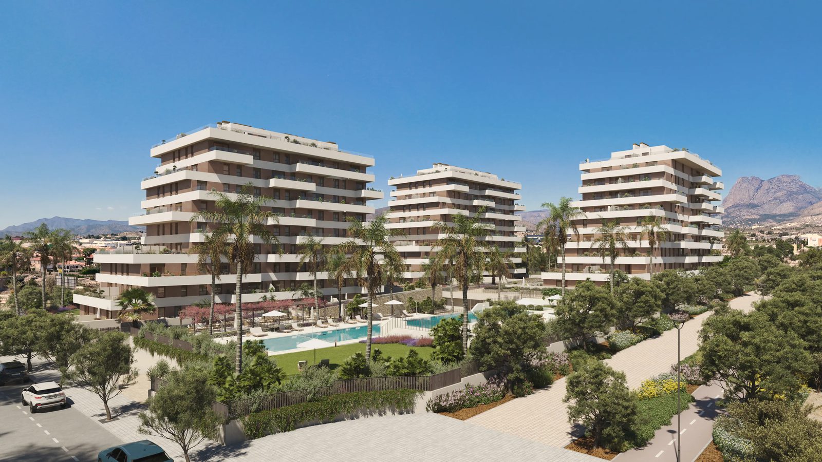 Exterior view of a modern apartment complex with a pool and gardens - The Estates