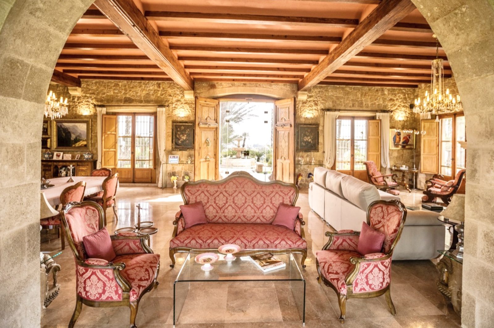Elegant living room with stone walls and exposed beams in a 7-bedroom finca in Denia - The Estates