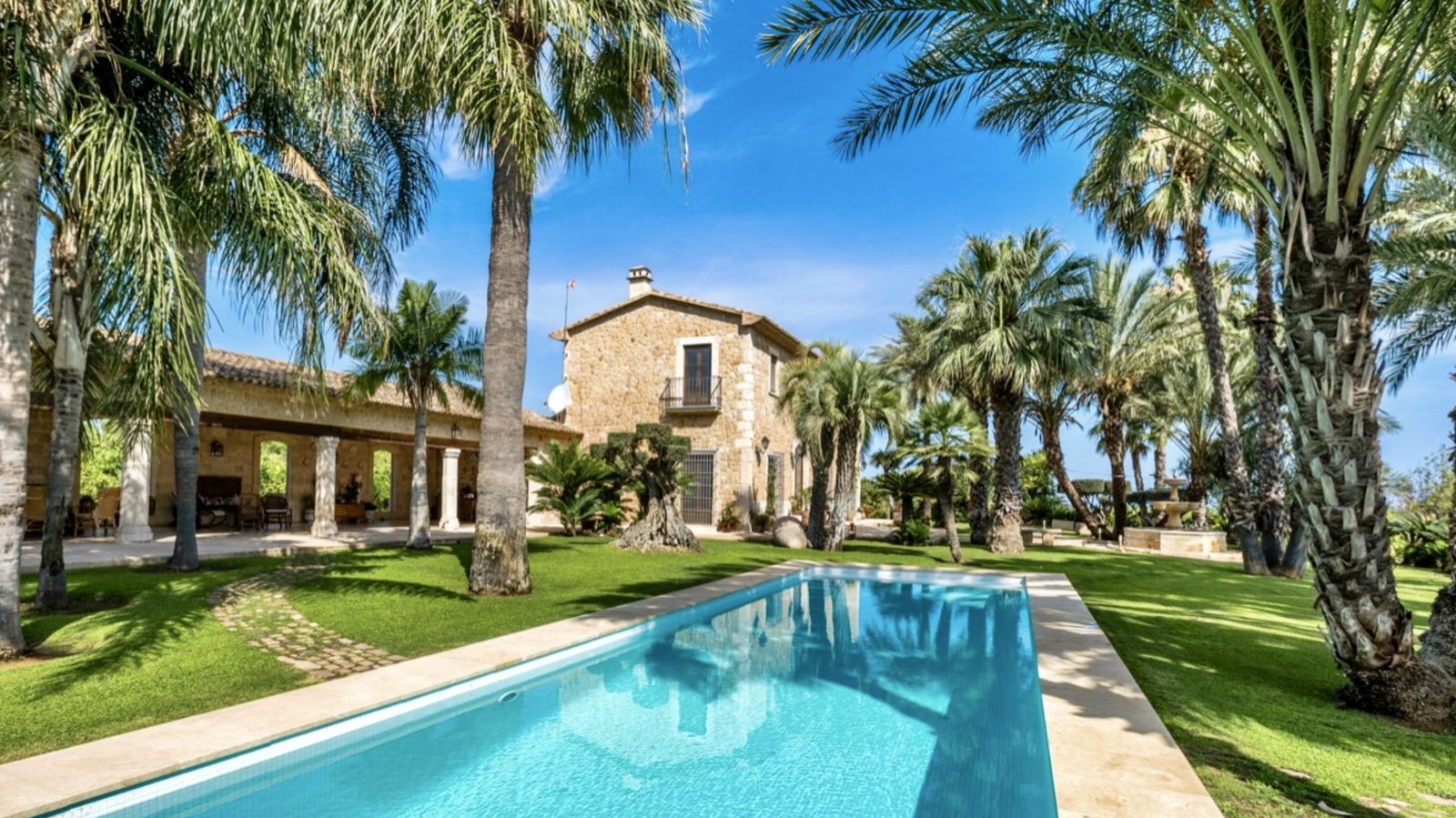 A beautiful pool and lush garden surround a stone finca in Denia - The Estates