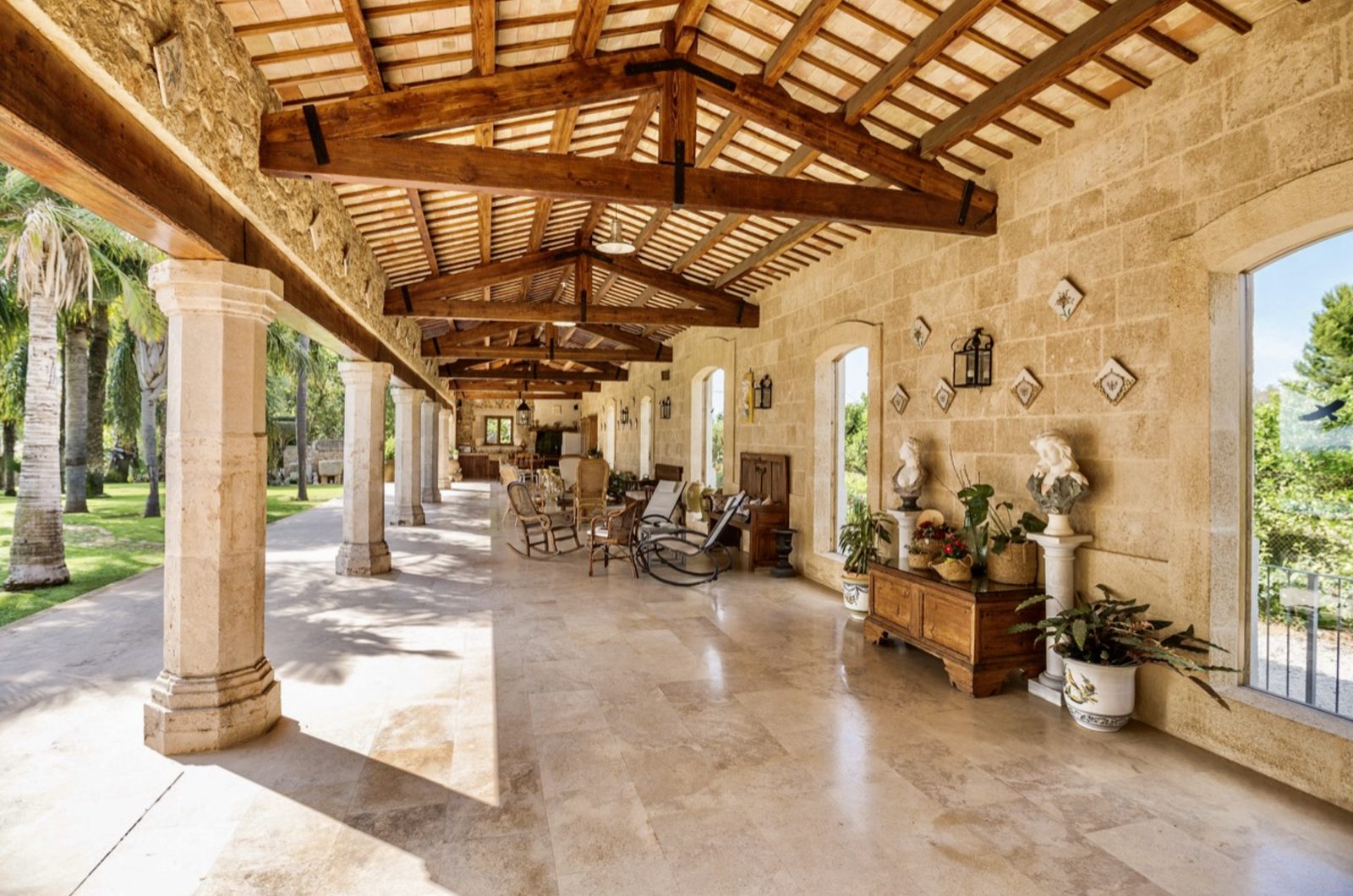 Covered terrace with stone pillars and wooden beams at a 7-bedroom finca in Denia - The Estates