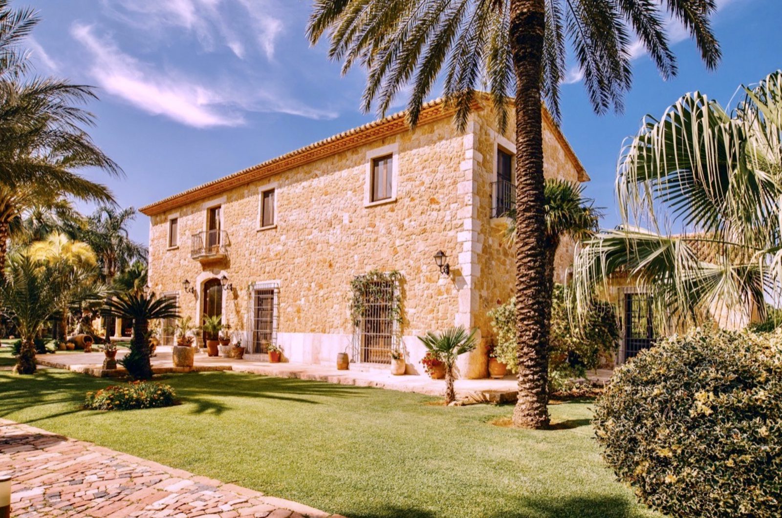 A beautiful stone finca with palm trees and a manicured lawn in Denia - The Estates