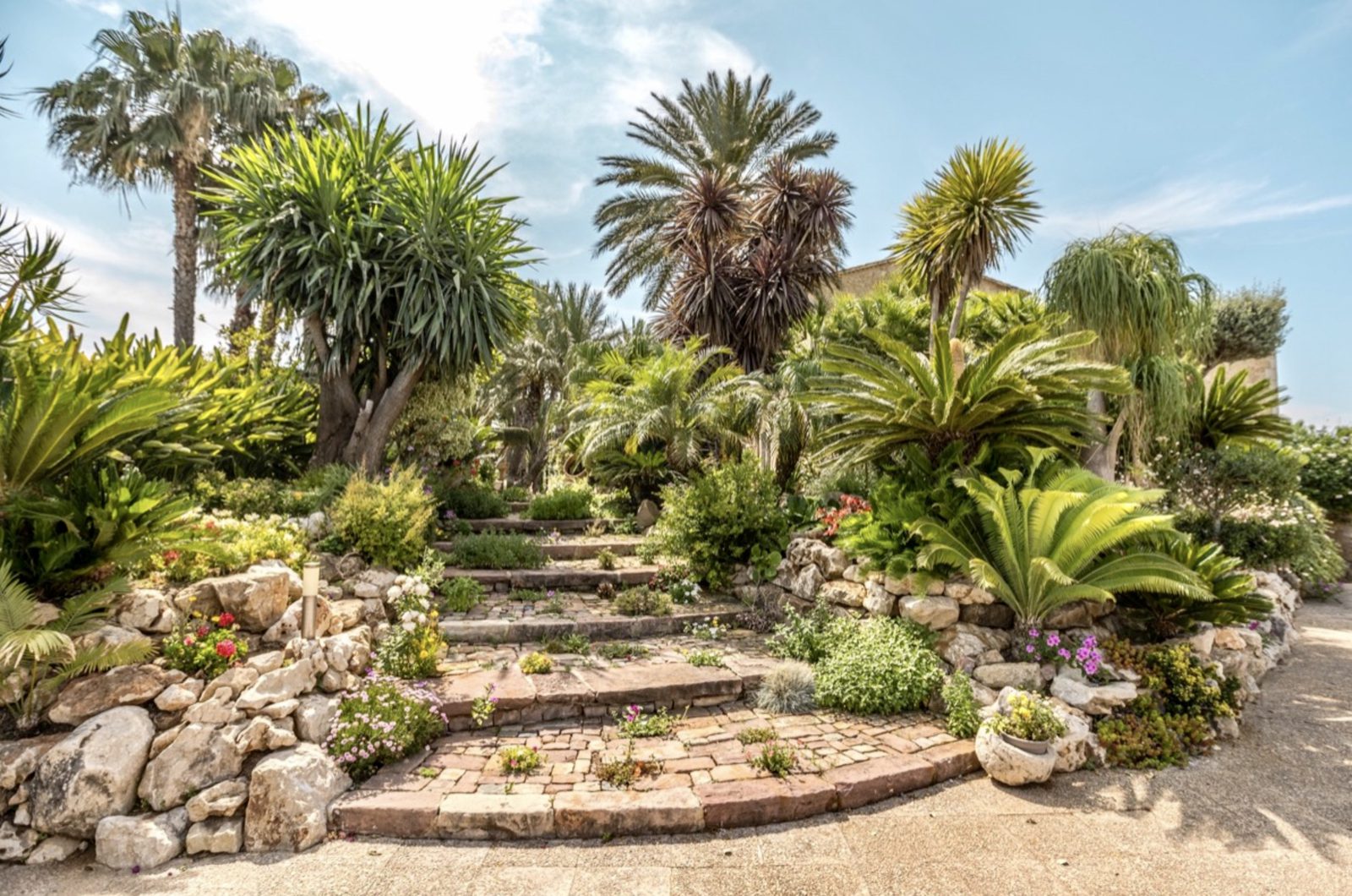 Lush garden with stone steps and palm trees on a 7-bedroom finca in Denia - The Estates