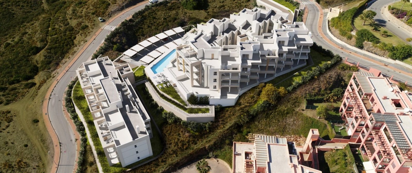 Aerial view of white apartment buildings and communal pool for a 2-bedroom apartment in Las