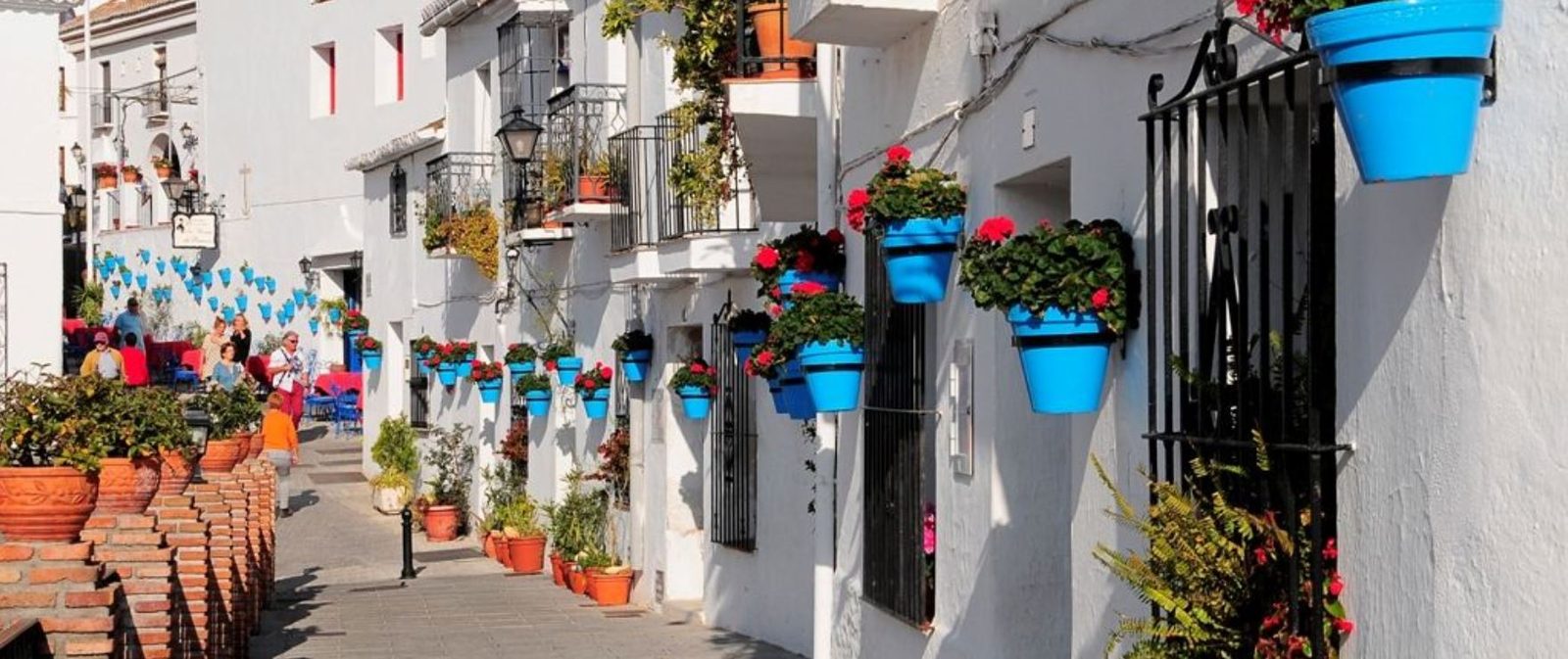 Whitewashed pedestrian street with flowerpots and balconies of a 2-bedroom apartment in Las Lagunas