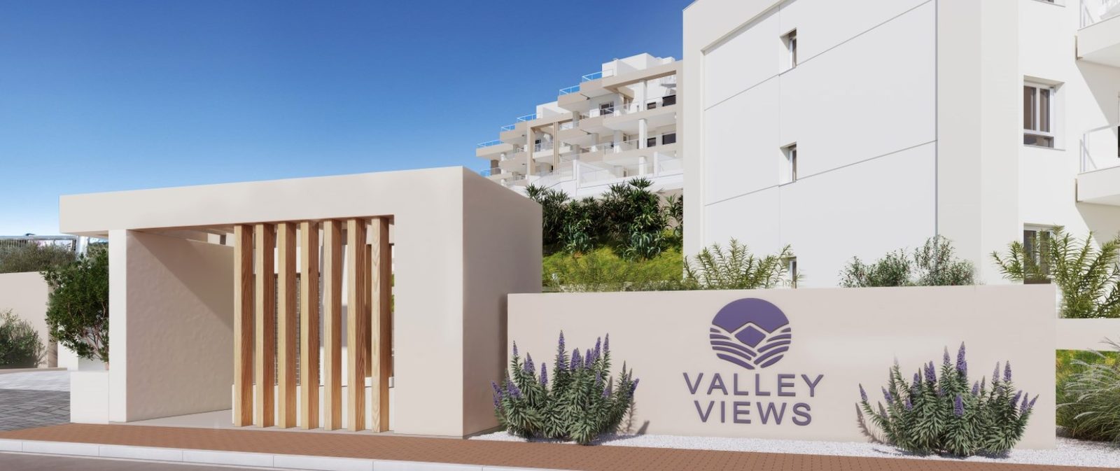 Modern Valley Views apartment development entrance with landscaped gardens and white buildings in Las Lagunas de Mijas - The Estates