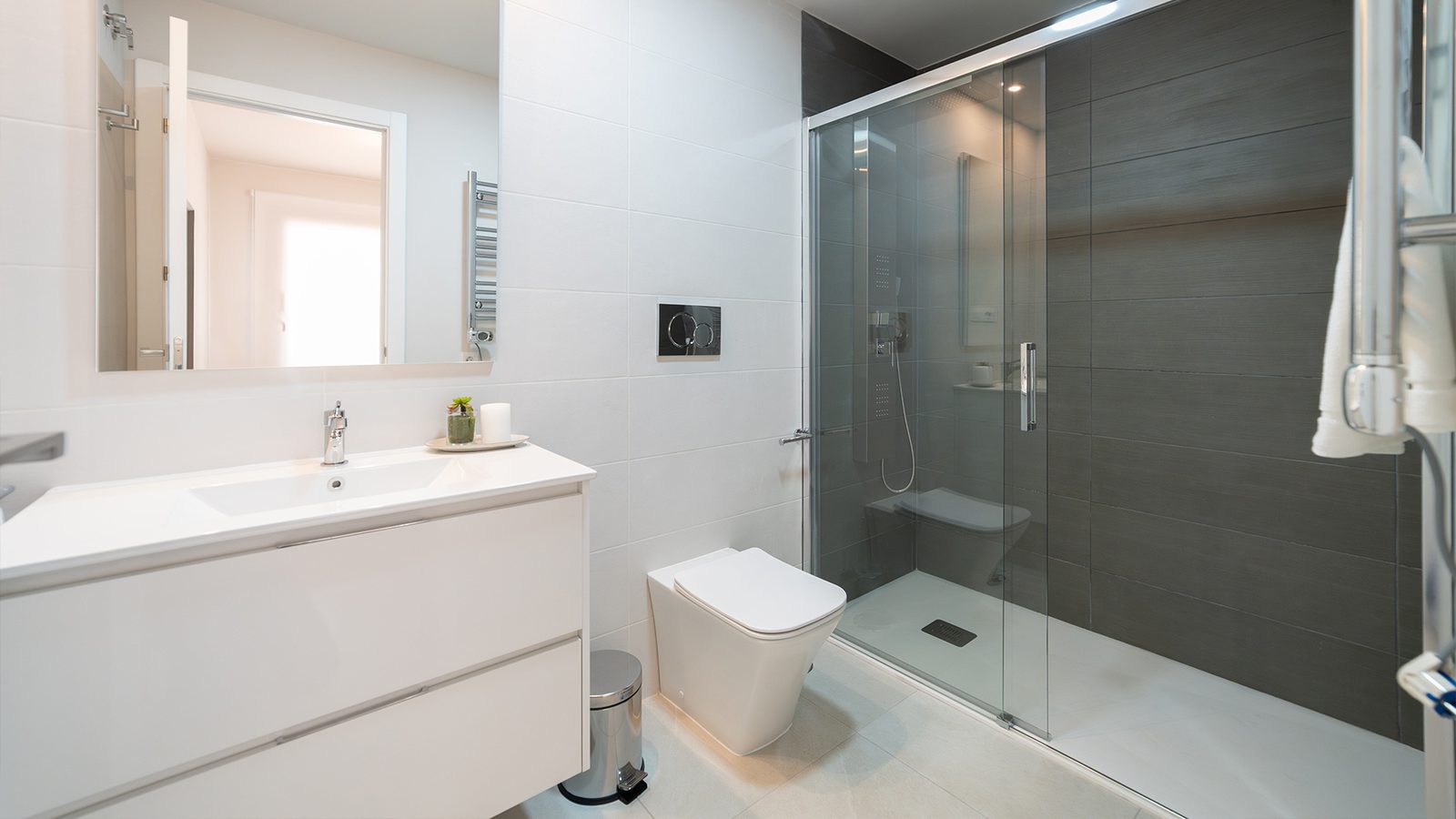 Modern bathroom with walk-in shower, wall-mounted toilet and white vanity in a 2-bedroom bungalow in Pulpí - The Estates