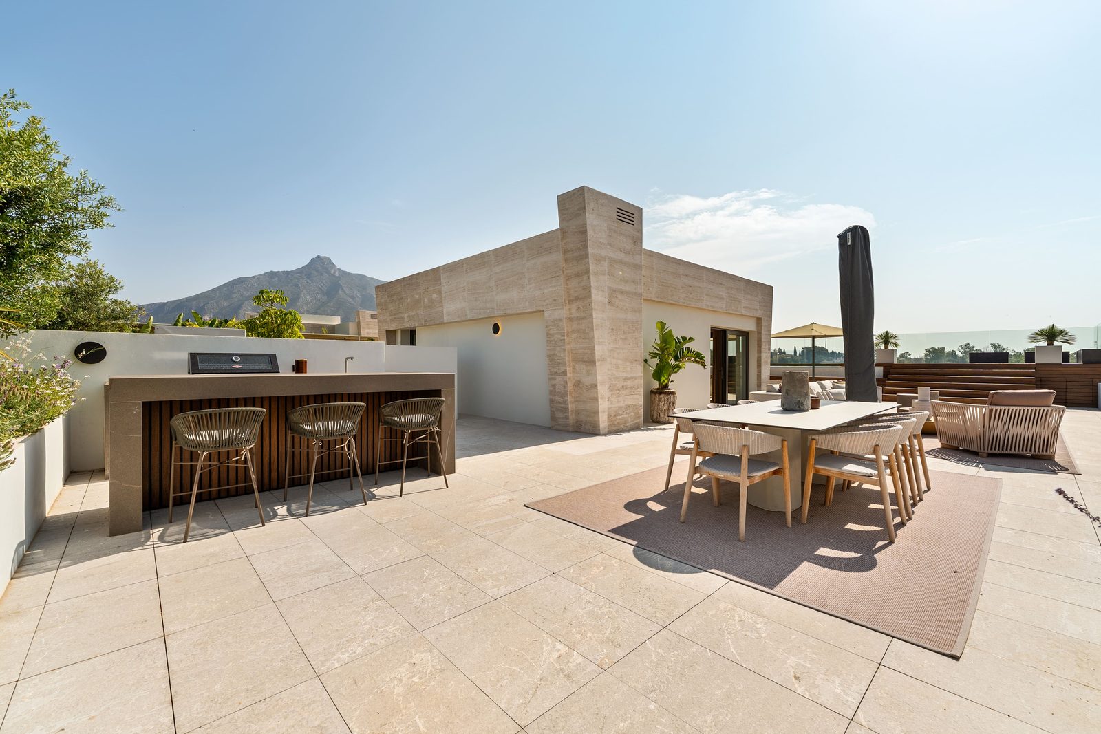 Rooftop terrace with outdoor kitchen, dining area and mountain views of a 4-bedroom penthouse in Málaga - The Estates