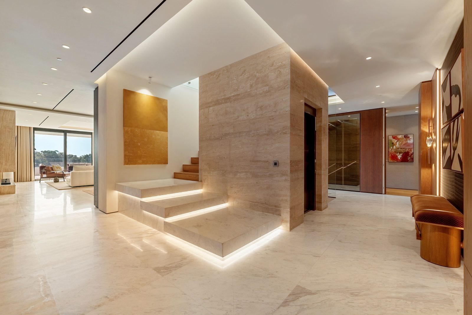 Marble entrance hall with illuminated stairs and contemporary art of a 4-bedroom
