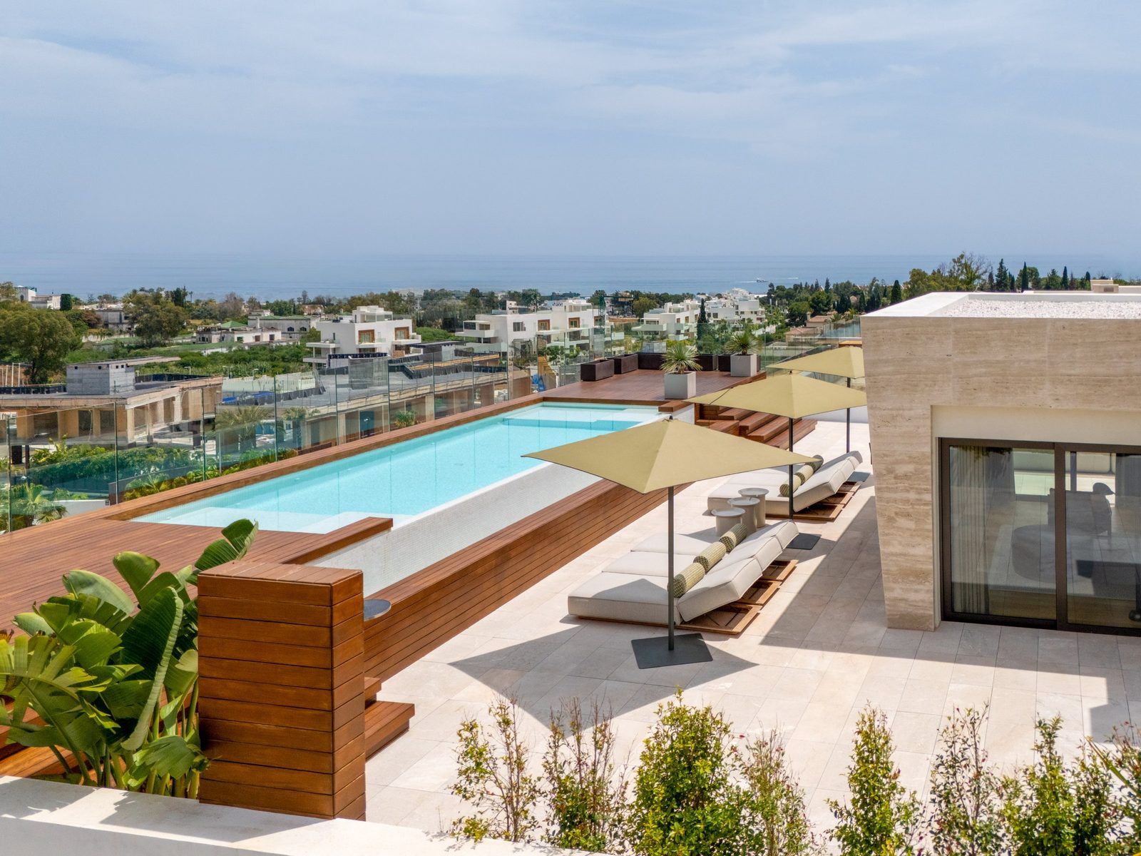 Rooftop pool terrace with loungers and sea views of a 4-bedroom penthouse in Málaga - The Estates