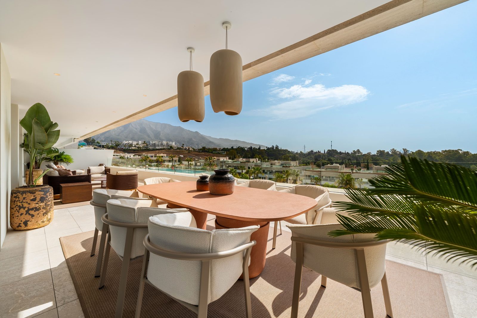 Covered terrace with dining table, lounge seating and mountain views of a