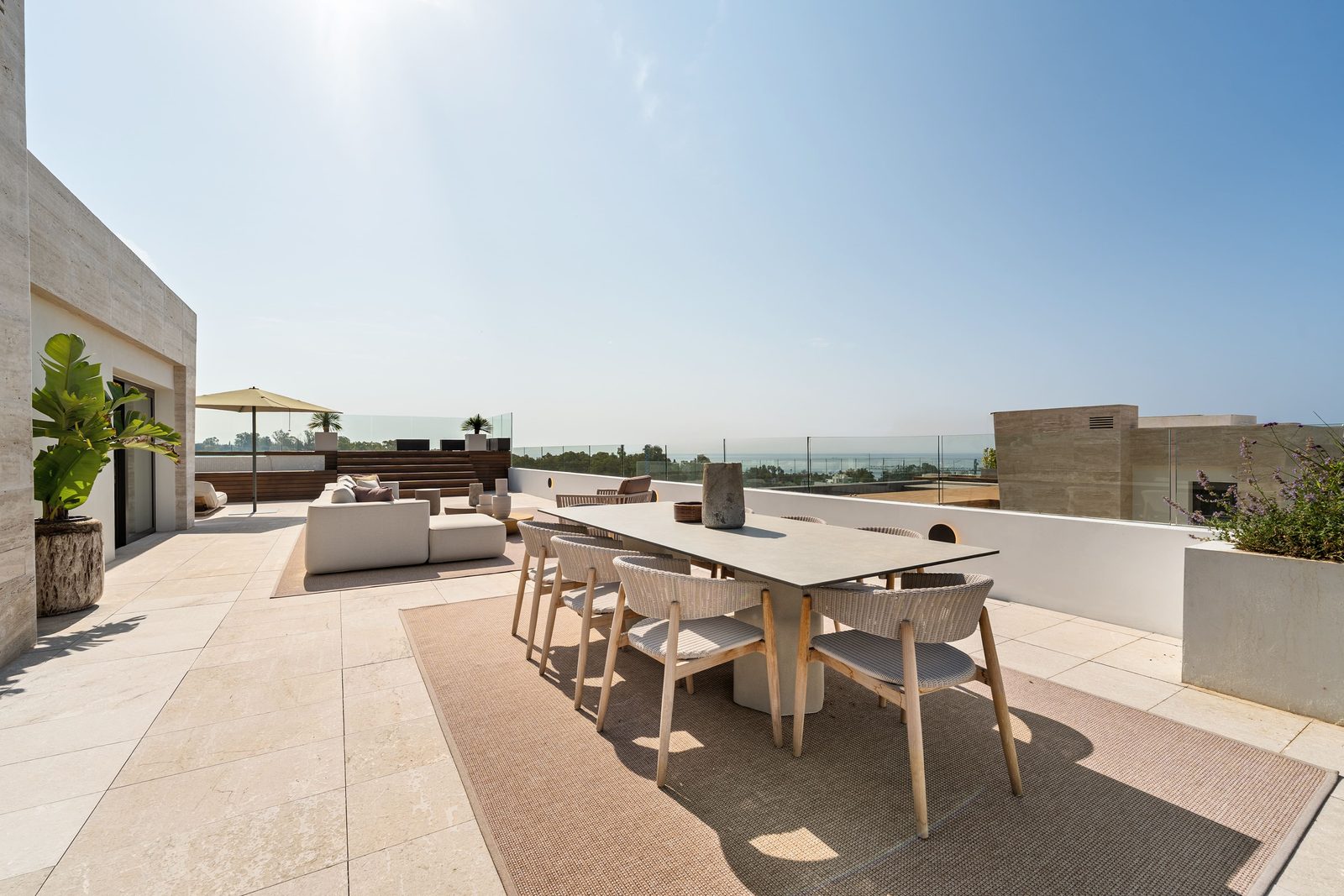 Rooftop terrace with outdoor dining and lounge areas overlooking the sea of a 4-bedroom penthouse in Málaga - The Estates