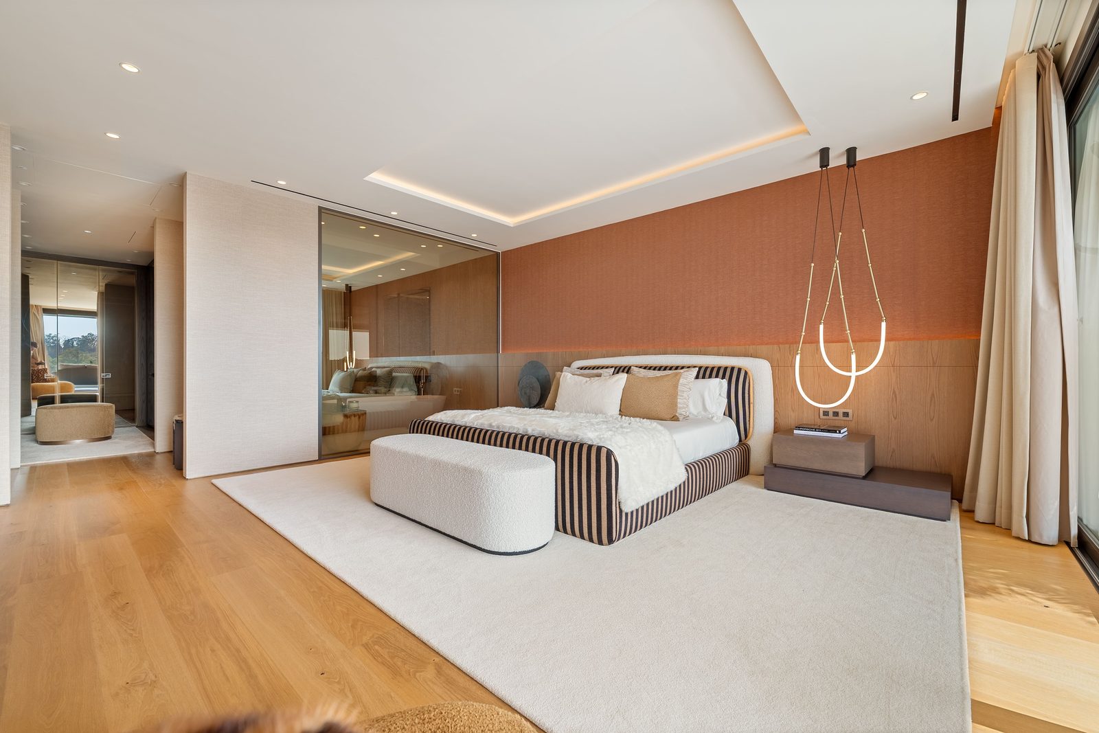 Contemporary master bedroom with striped upholstered bed, wood panel wall and pendant lights in a 4-bedroom penthouse in Málaga - The Estates