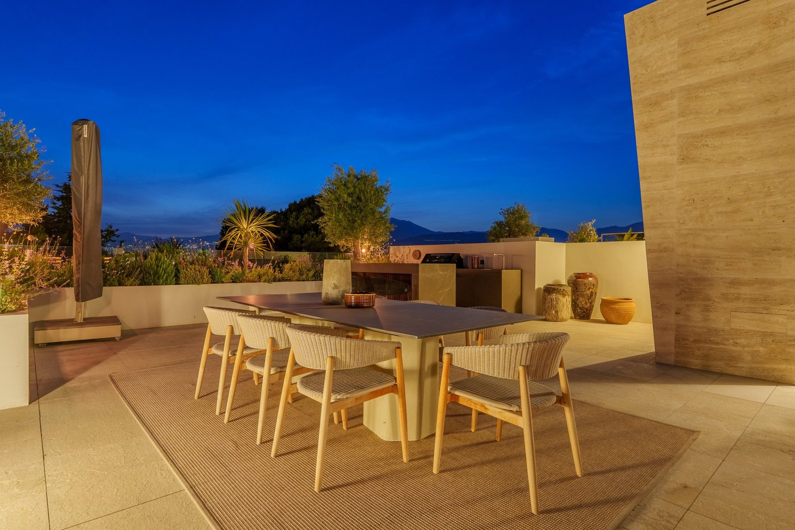 Rooftop terrace with dining area, outdoor kitchen and sea and mountain views of a 4-bedroom penthouse in Málaga - The Estates