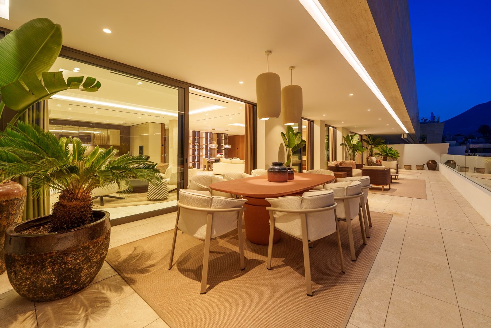 Covered terrace with outdoor dining area, designer seating and mountain views of a 4-bedroom penthouse