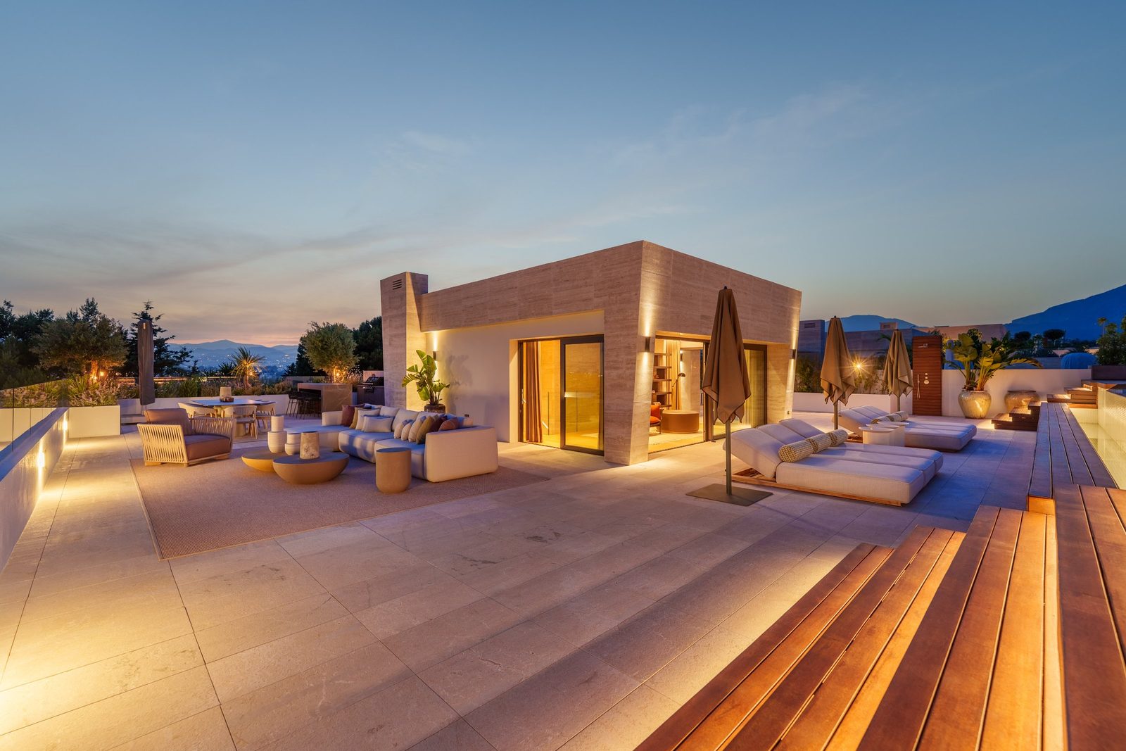 Sunset rooftop terrace with lounge seating, outdoor dining and sea and mountain views at a 4-bedroom penthouse in Málaga - The Estates