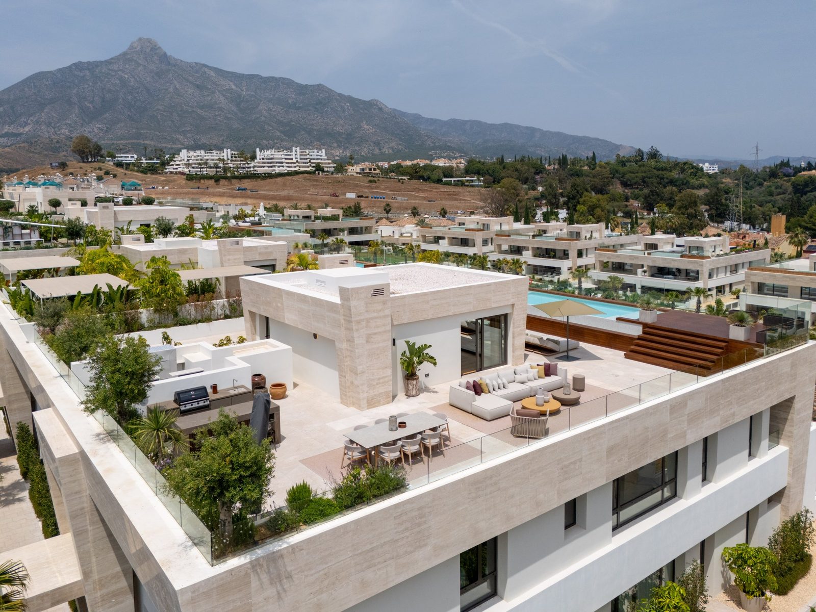 Rooftop terrace with outdoor dining, lounge seating and pool overlooking Marbella’s mountains - The Estates