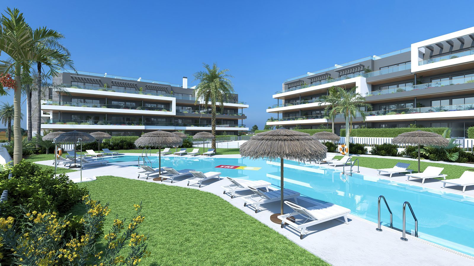 Communal swimming pool with sun loungers and thatched umbrellas between modern apartment buildings in Torrevieja - The Estates