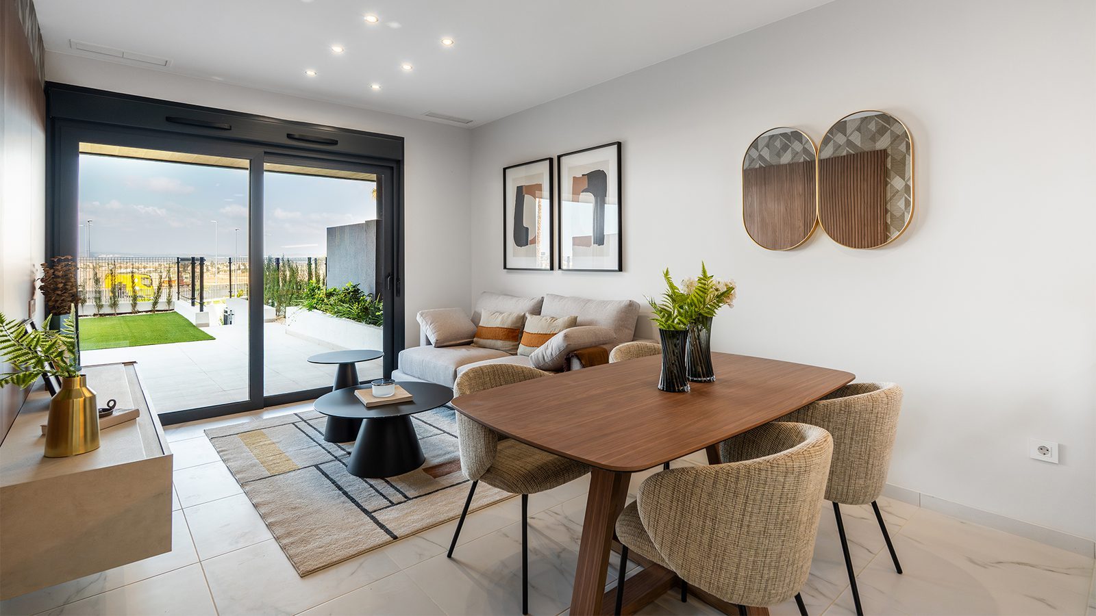 Modern living and dining room opening onto a landscaped terrace of a 3-bedroom apartment in Torrevieja - The Estates