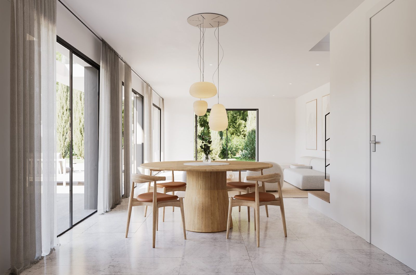 Bright dining room with round wooden table and garden views in a 4-bedroom villa in Jávea