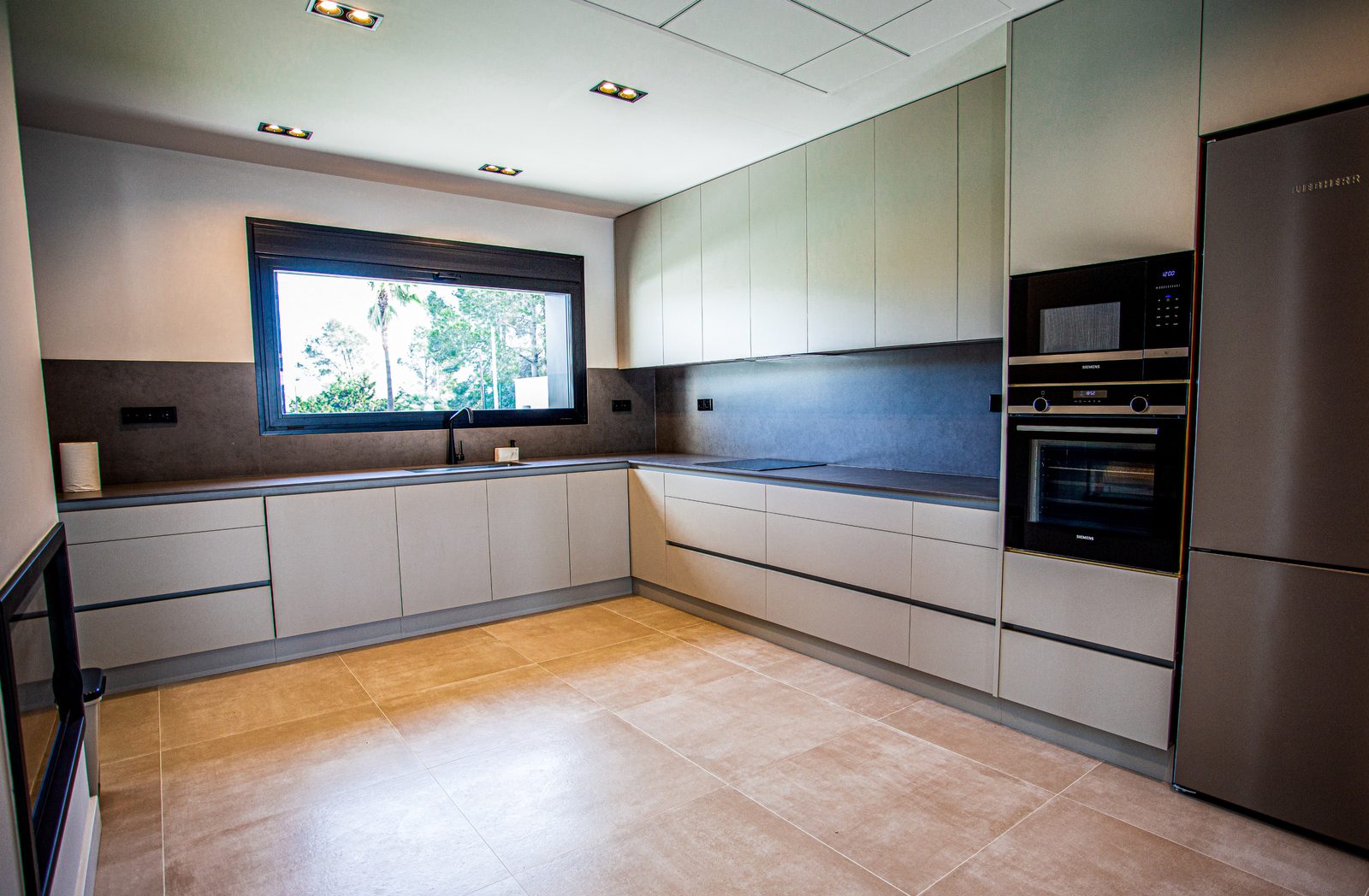 Modern kitchen with window views in a 3-bedroom villa in Denia - The Estates