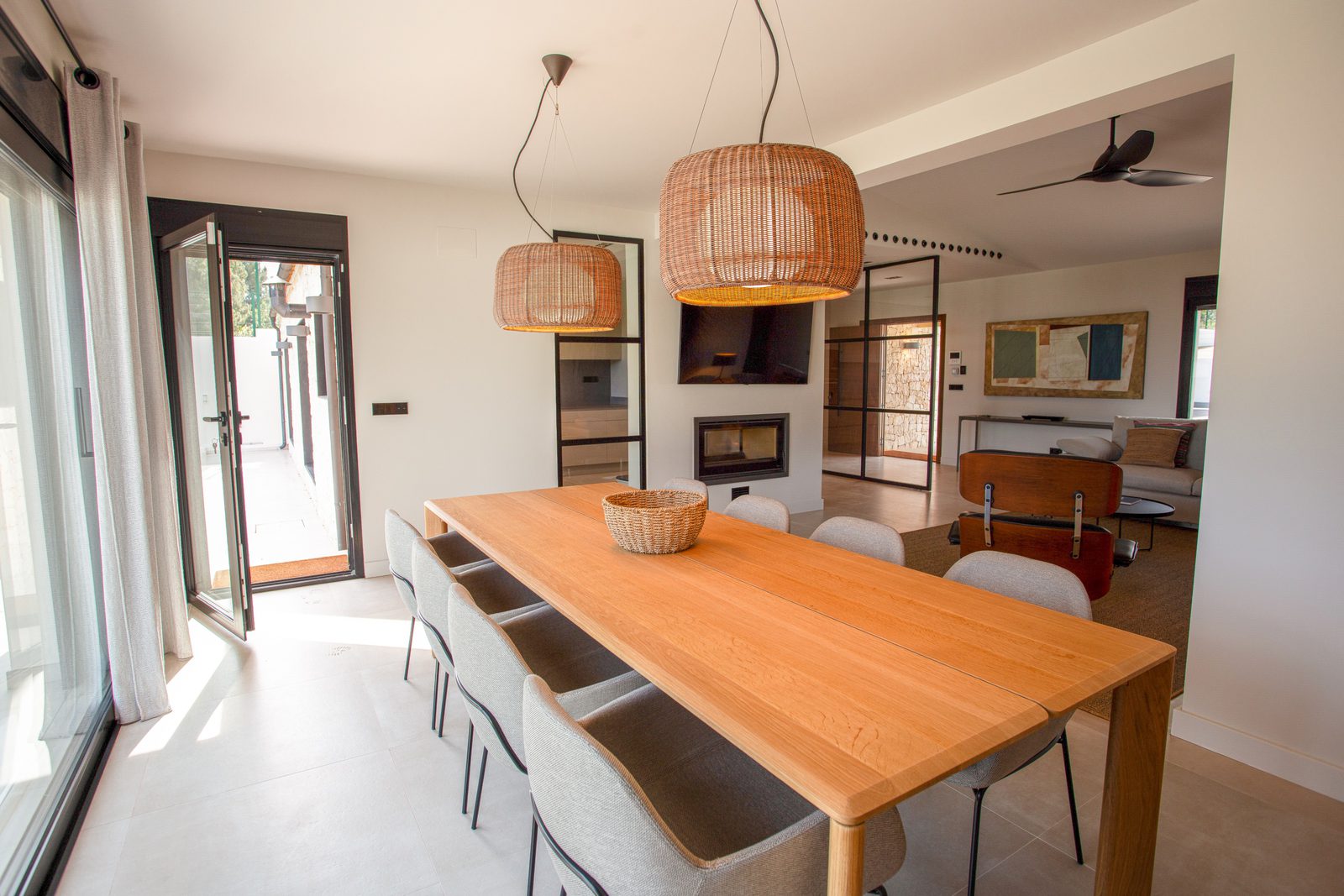 A bright dining area with modern lighting and a fireplace in a 3-bedroom villa in Denia - The Estates
