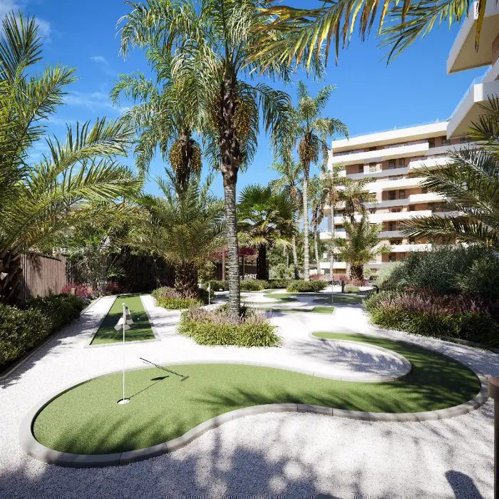 A putting green and palm trees with a building in the background of a 3-bedroom penthouse in Villajoyosa - The Estates