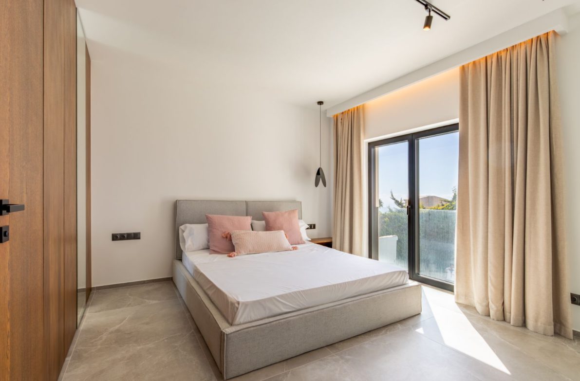 A bright bedroom with large windows and elegant curtains in a 5-bedroom villa in Benitachell - The Estates