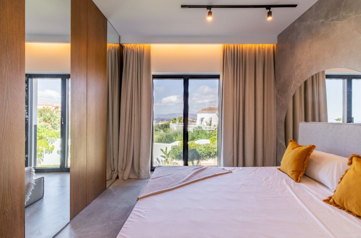 Stylish bedroom interior with large windows and mountain views of a 5-bedroom villa in Benitachell - The Estates