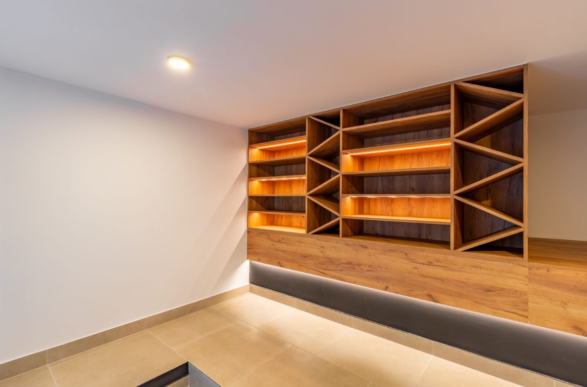Stylish built-in wooden shelving with warm lighting in a 5-bedroom villa in Benitachell - The Estates