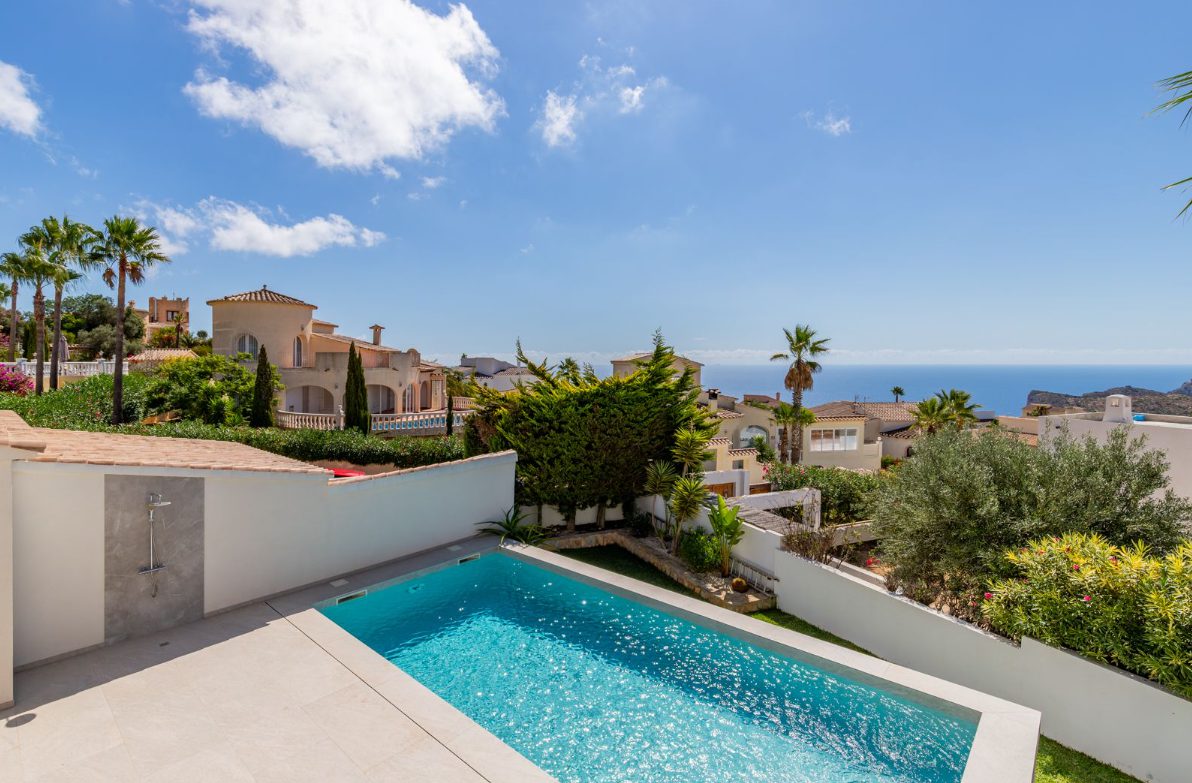 A beautiful pool and villa exterior with sea and mountain views of a 5-bedroom villa in Benitachell - The Estates