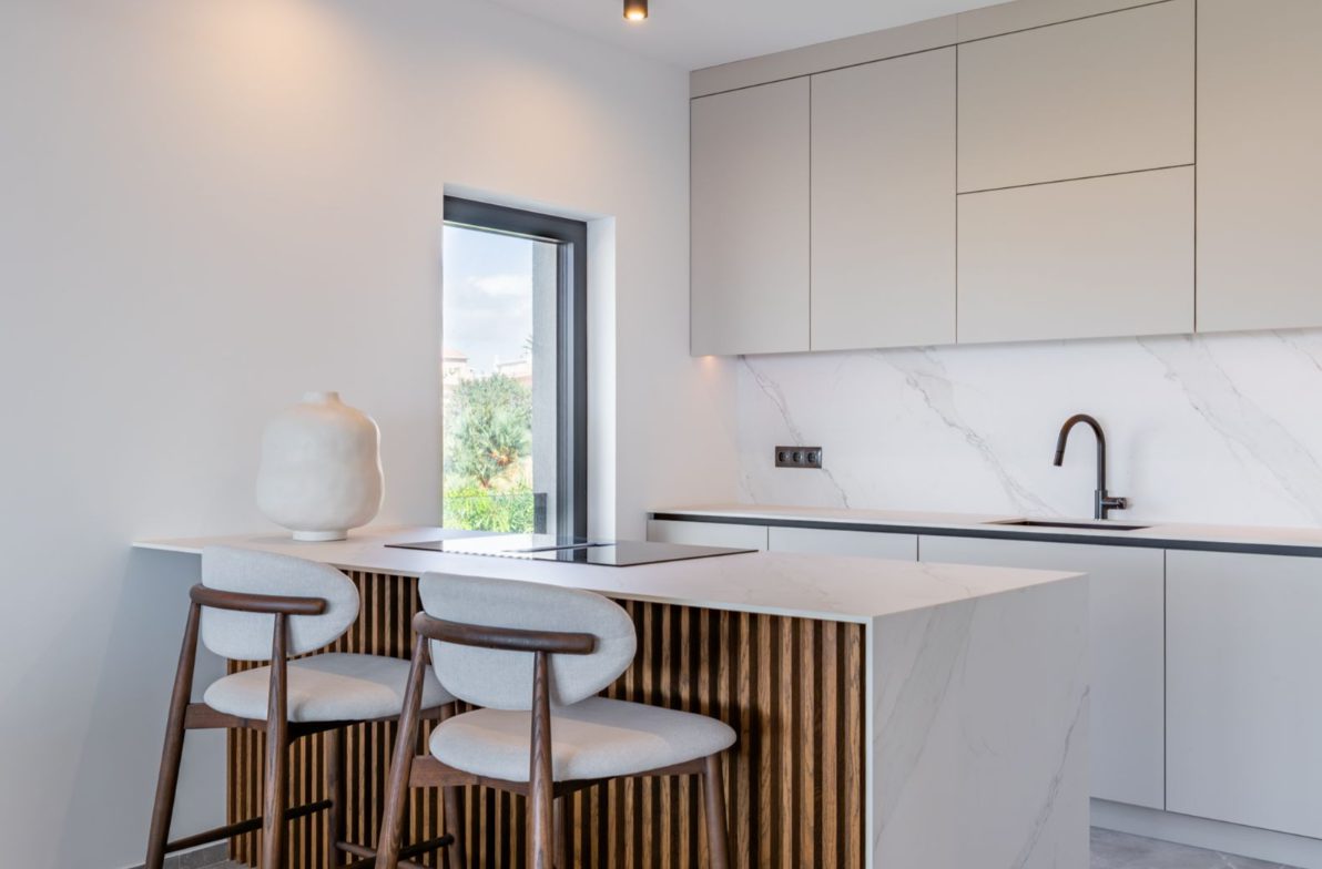 Modern kitchen with marble countertops and a window view of a 5-bedroom villa in Benitachell - The Estates