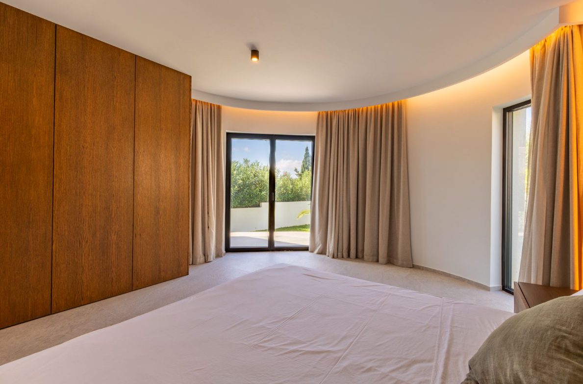 Stylish bedroom interior with large windows and views of greenery in a 5-bedroom villa in Benitachell - The Estates