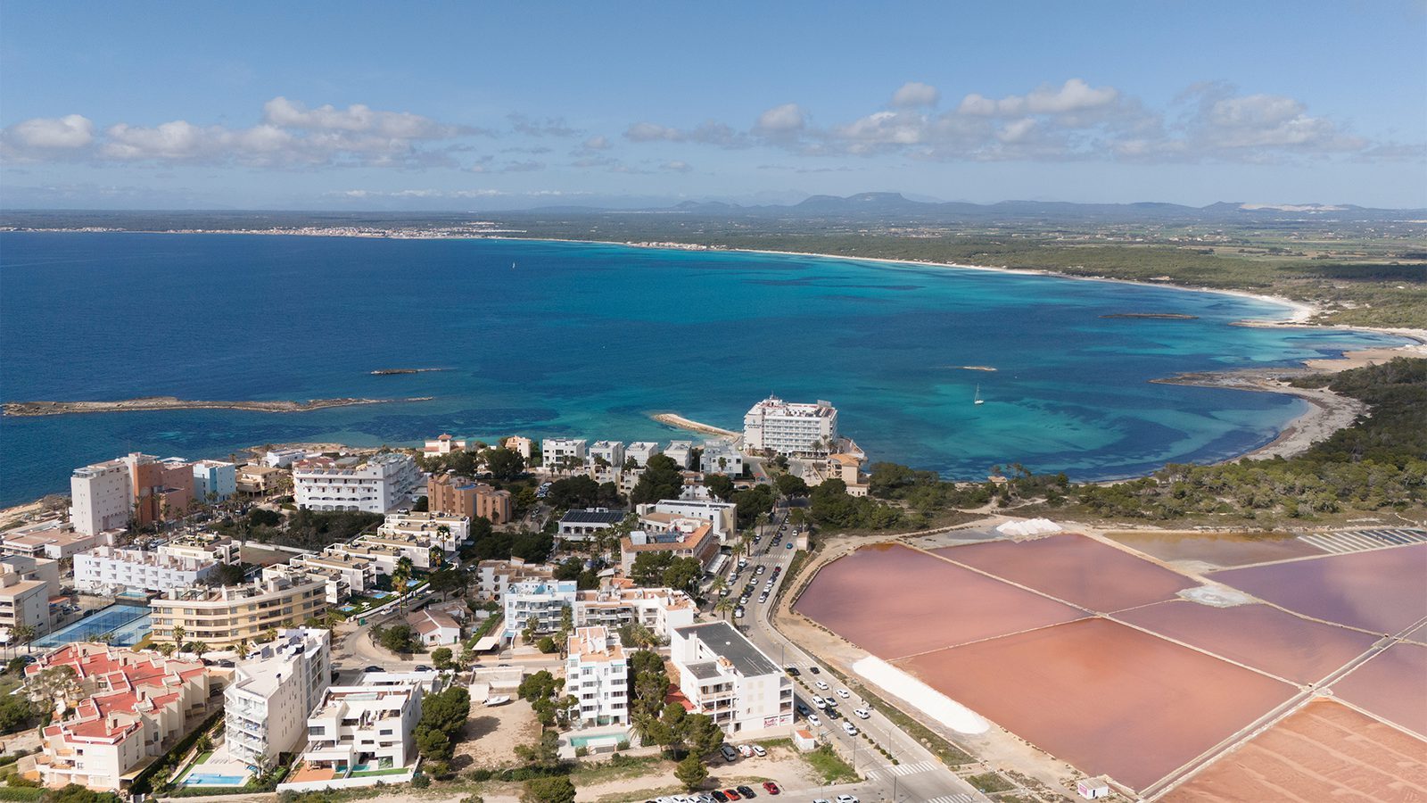 Aerial view of Colonia de Sant Jordi, turquoise coastline, salt flats and surrounding apartments in Mallorca - The Estates