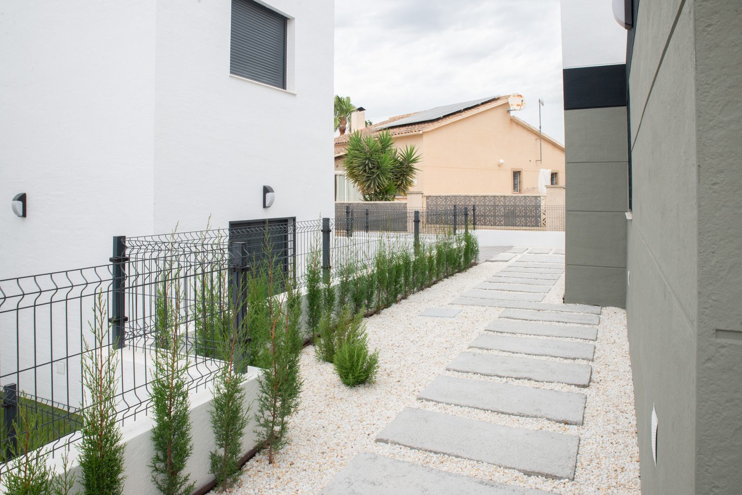 Landscaped side garden with gravel path and stepping stones of a 3-bedroom villa in Busot, zona Bonalba Golf