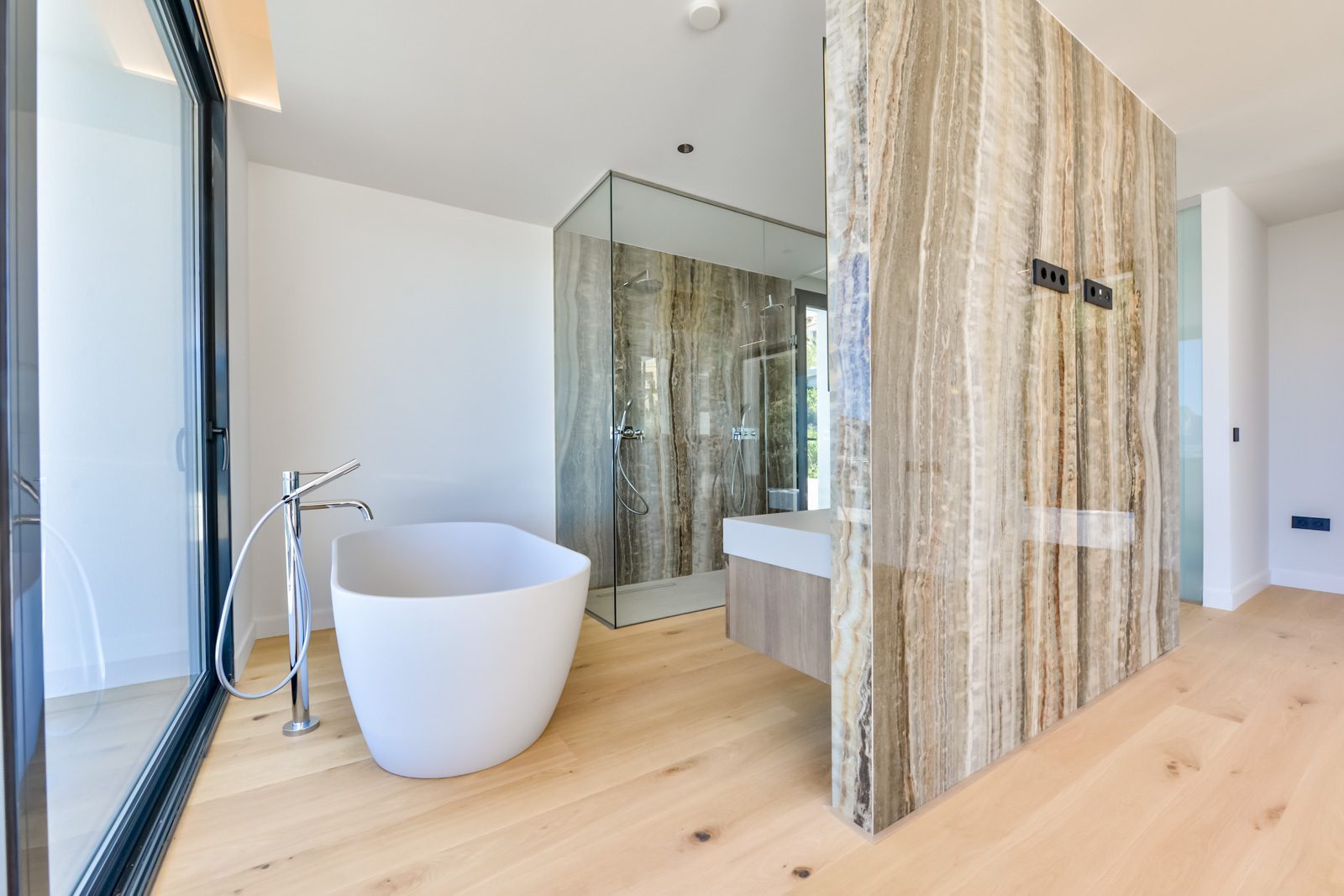 Contemporary bathroom with freestanding tub, glass shower and stone wall of a 4-bedroom villa in Altea - The Estates