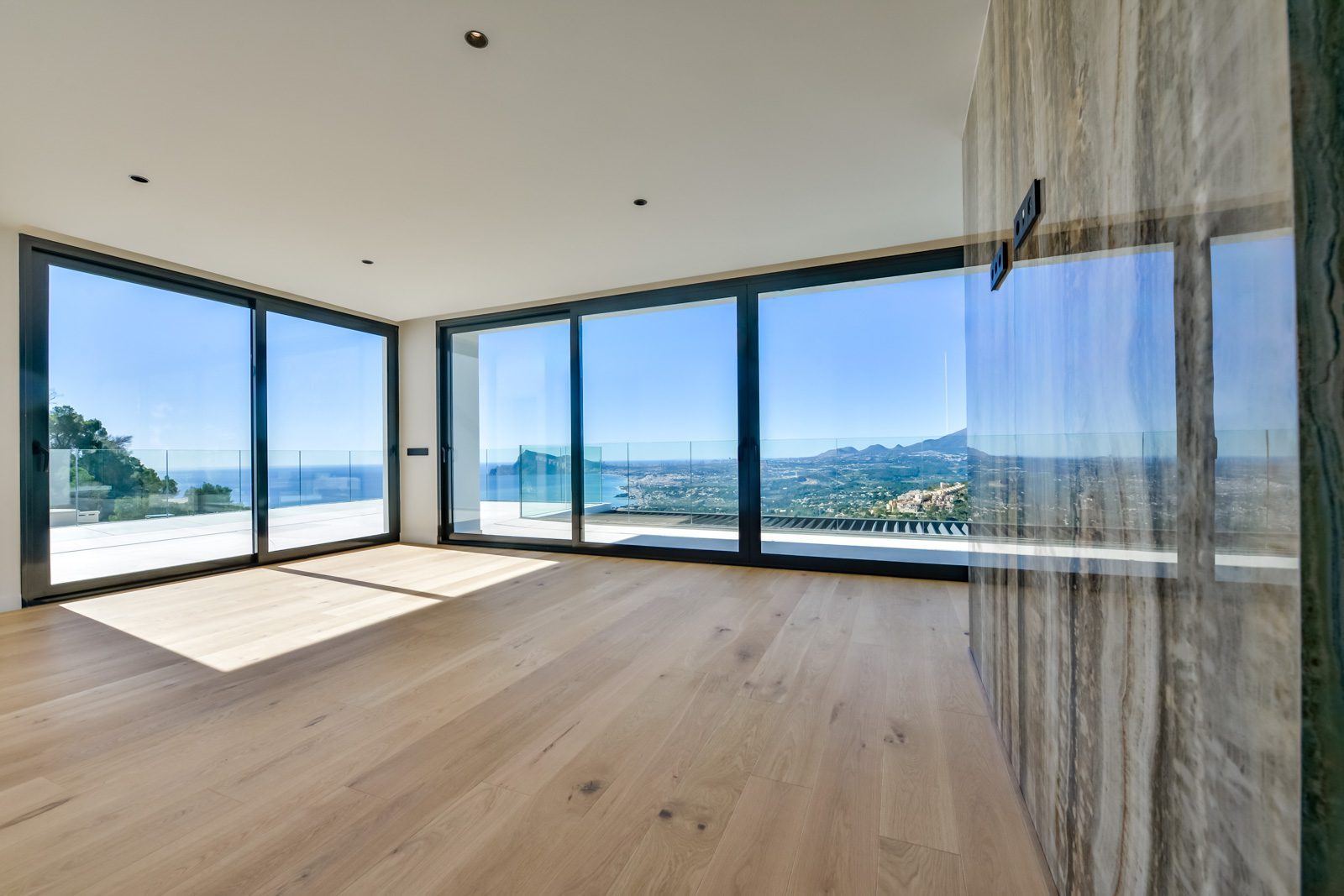 Bright room with floor-to-ceiling windows and panoramic sea views of a