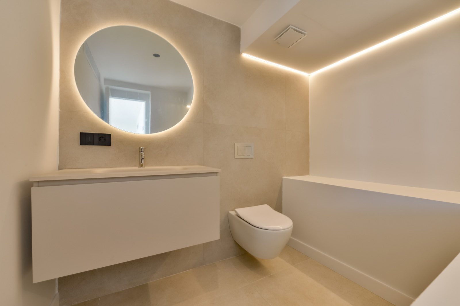 Modern bathroom with floating vanity, backlit round mirror