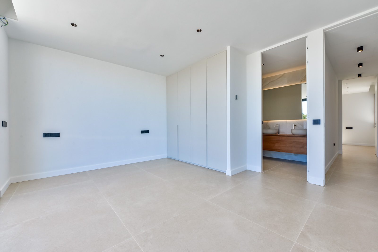 Modern white bedroom with fitted wardrobes and ensuite bathroom in a 4-bedroom villa in Altea - The Estates