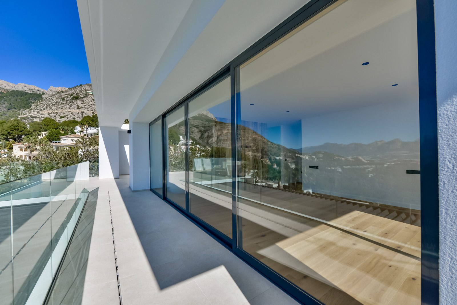 Modern terrace with floor-to-ceiling windows and mountain views of a 4-bedroom villa in Altea - The Estates