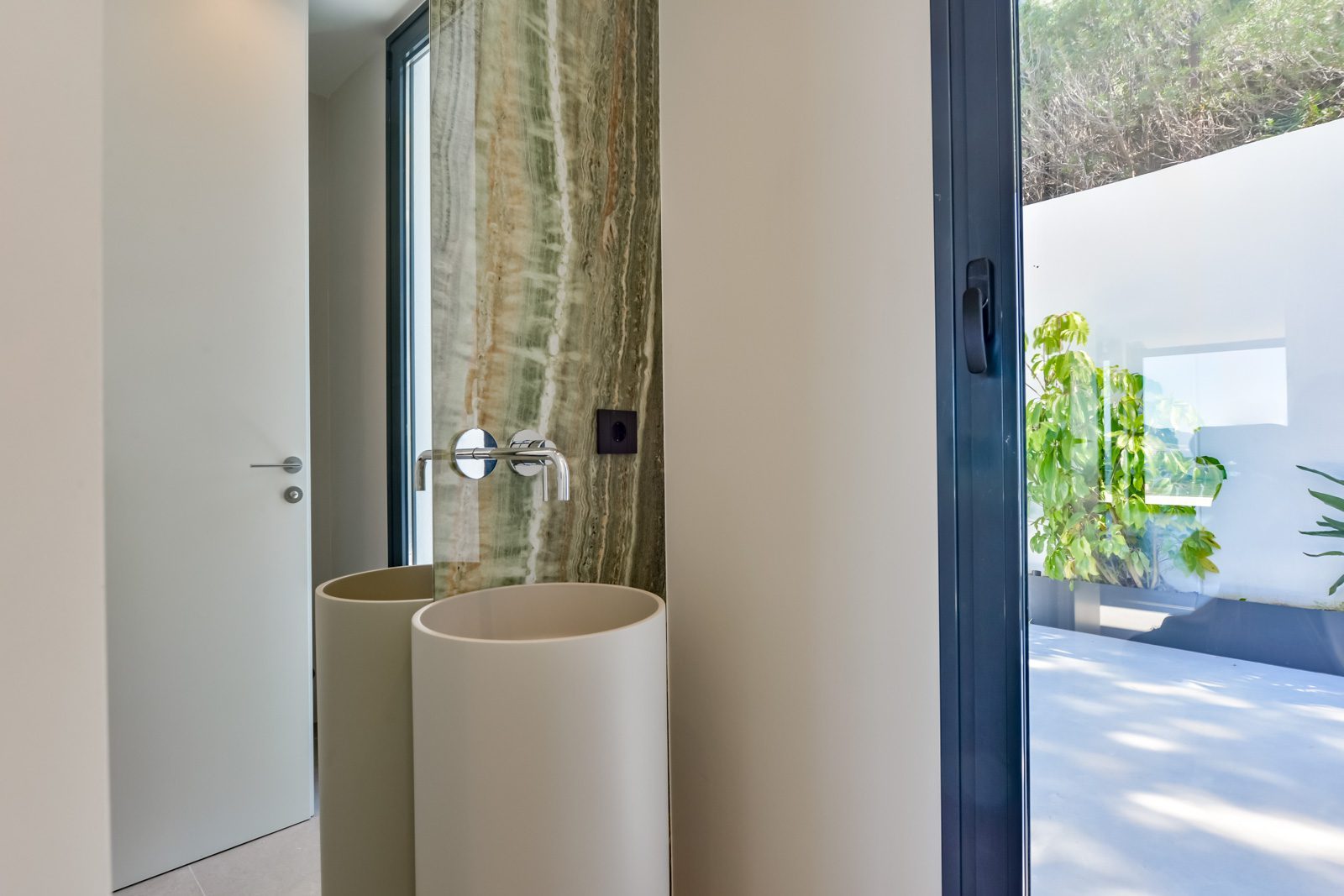 Modern bathroom with a freestanding basin, stone feature wall and garden view of a 4-bedroom villa in Altea - The Estates