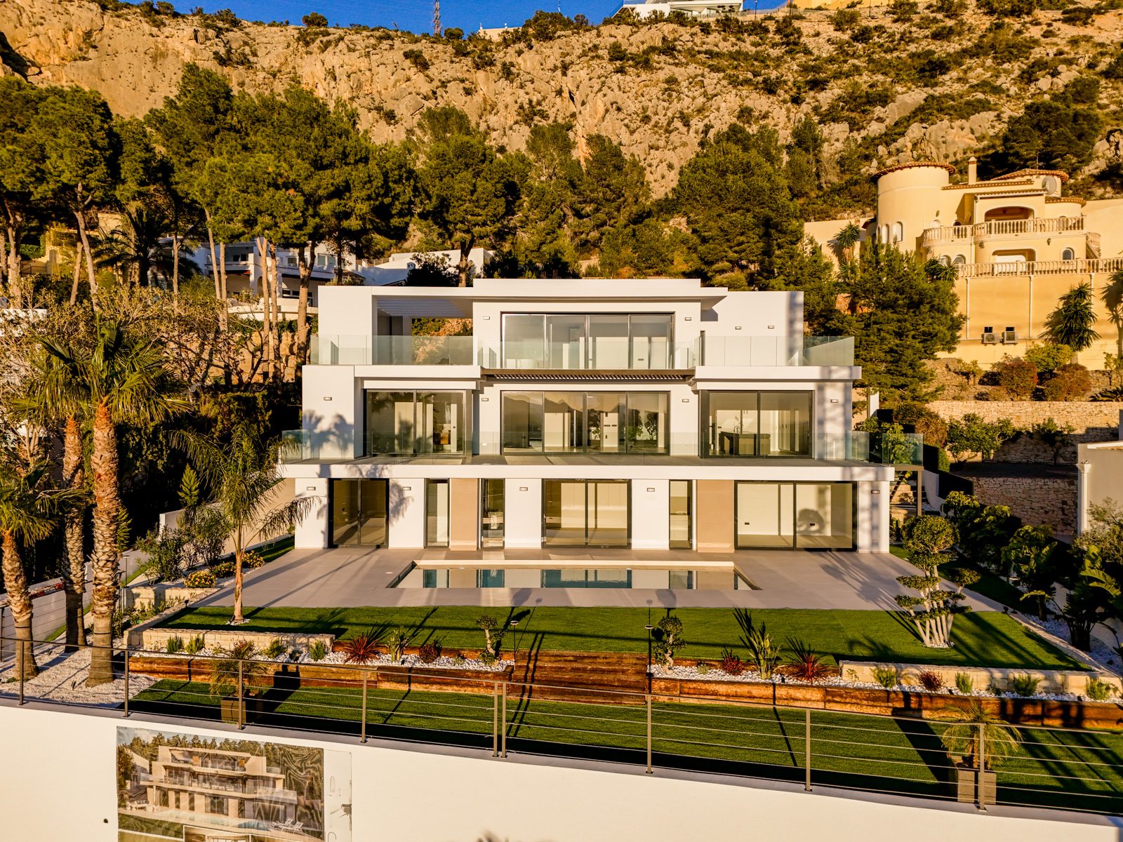 Modern four-bedroom villa with pool and landscaped garden beneath rugged hills in Altea - The Estates