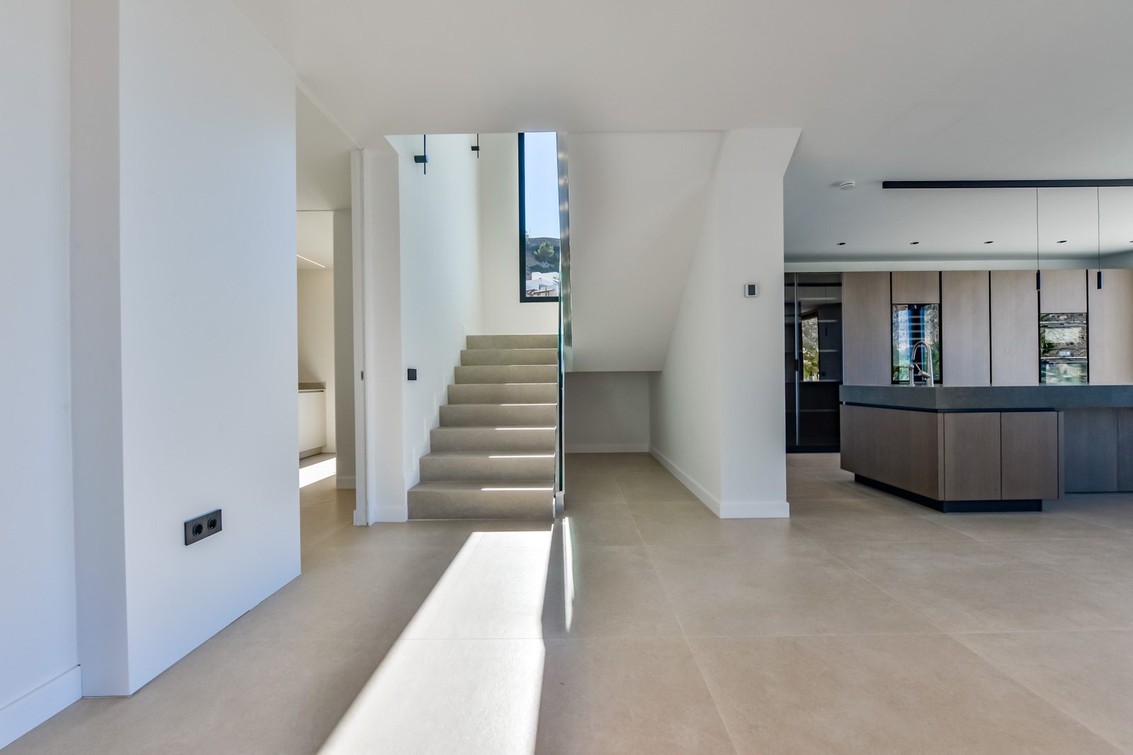 Open-plan villa interior with staircase and modern kitchen in Altea - The Estates