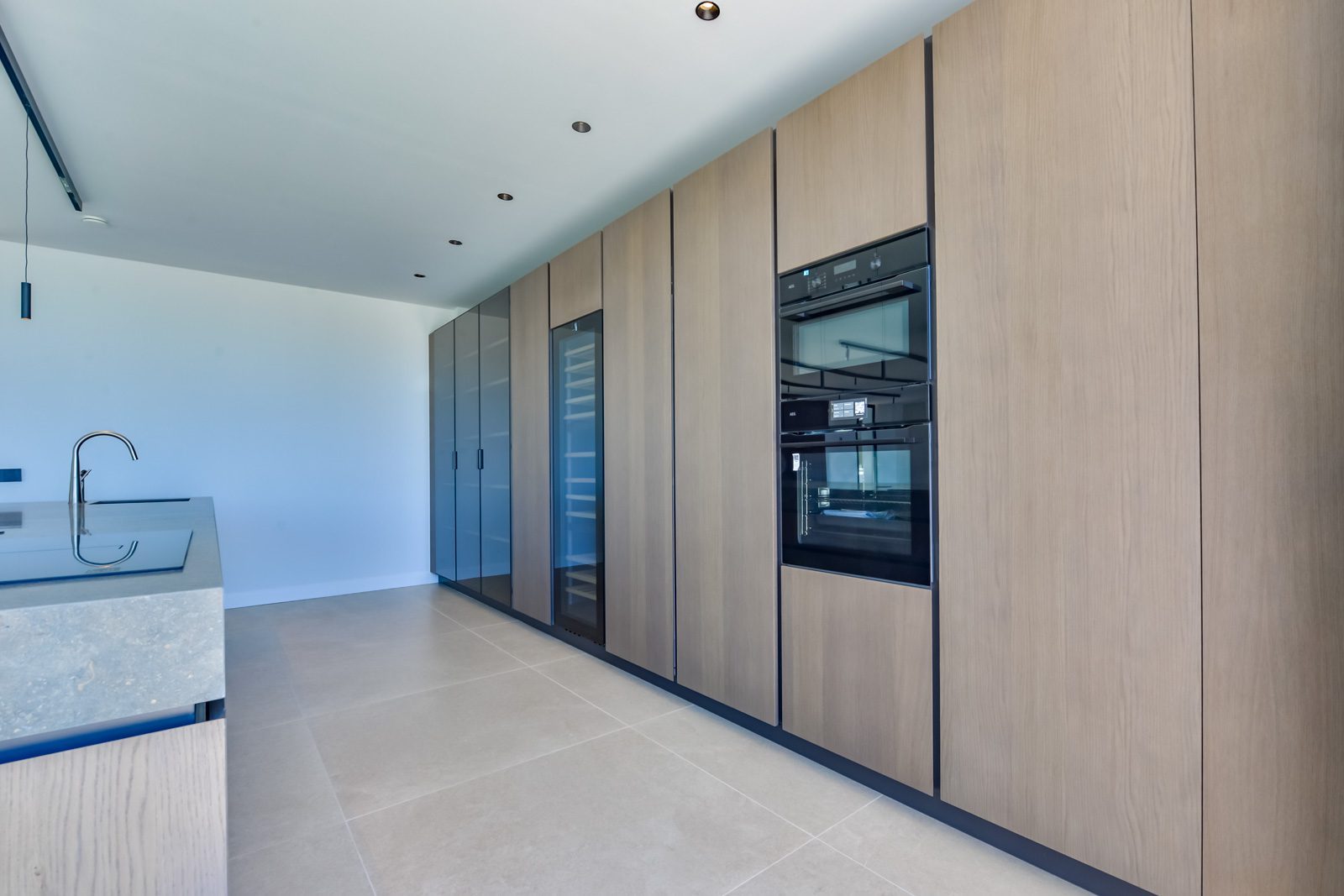 Modern kitchen with wood cabinetry, built-in appliances and island in a 4-bedroom villa in Altea - The Estates