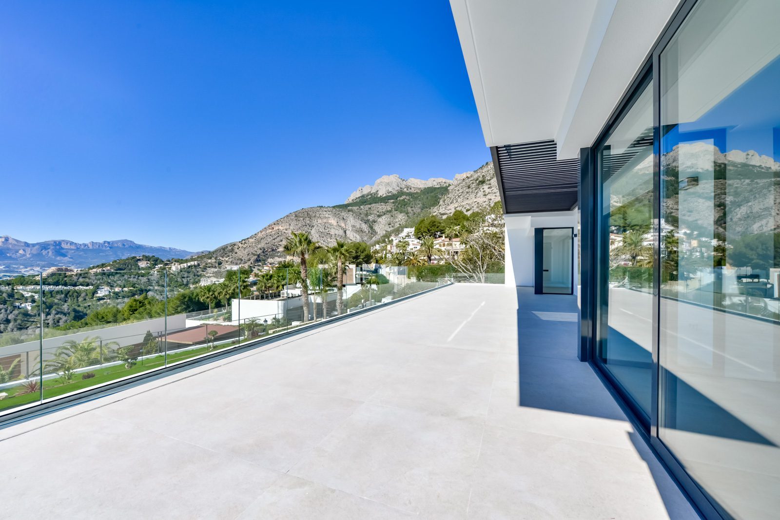 Spacious terrace with glass railings and panoramic sea