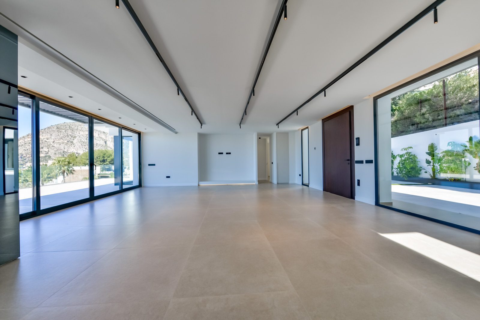 Bright open-plan living room with floor-to-ceiling windows and mountain views
