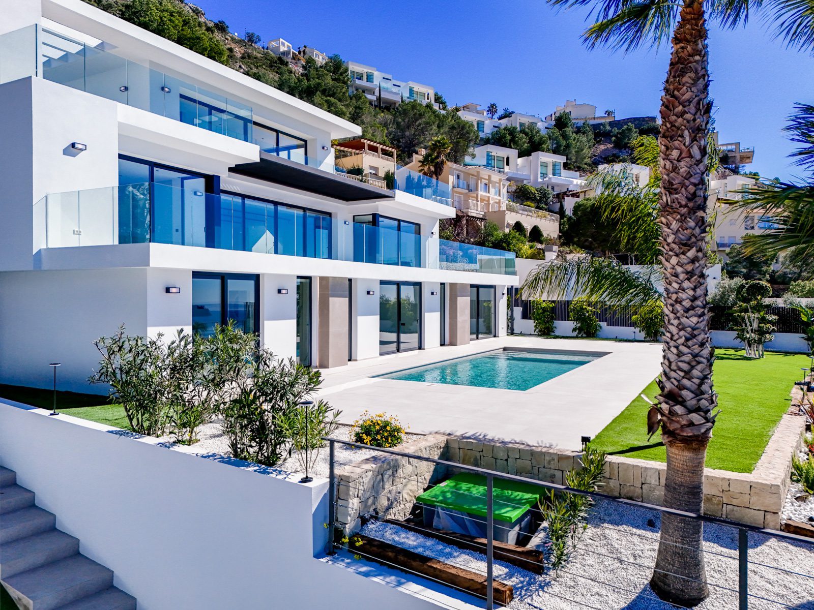 Modern white villa with pool, glass balconies and palm garden of a 4-bedroom villa in Al