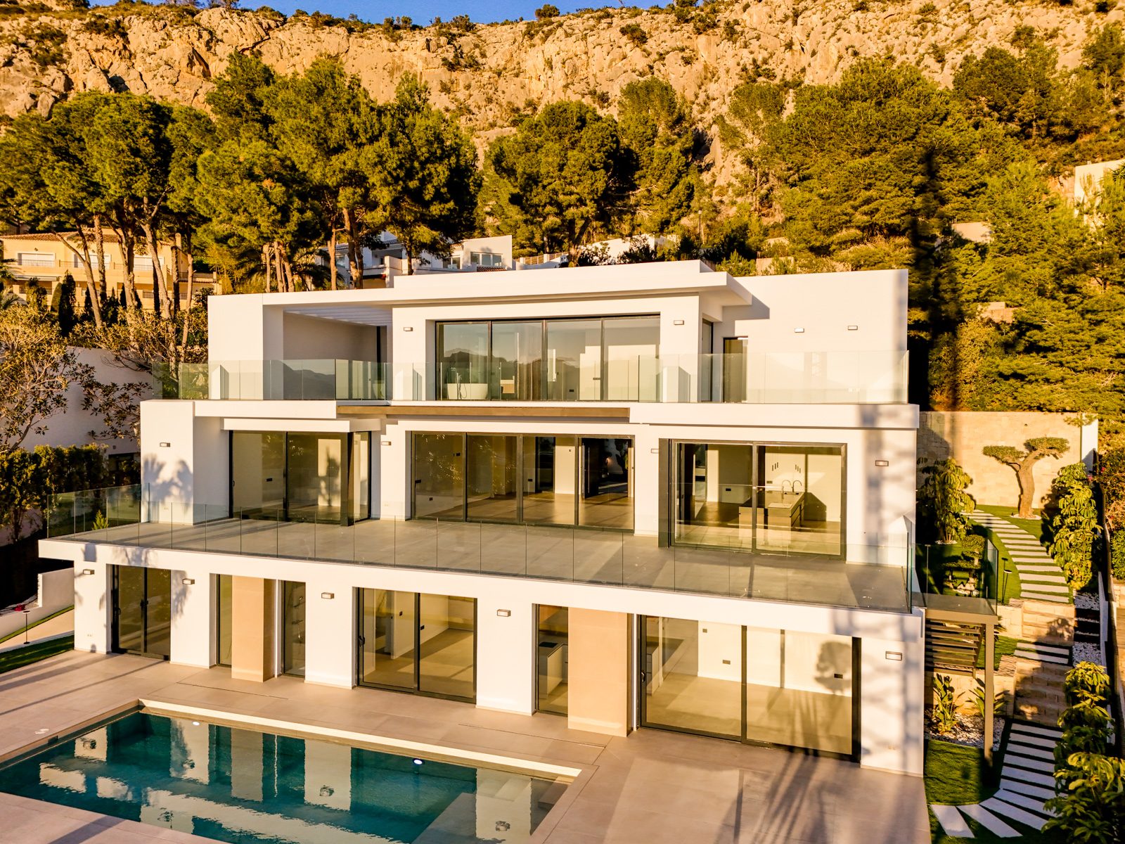 Modern white villa with pool and rocky hillside backdrop, exterior view of a 4-bedroom villa in Altea - The Estates