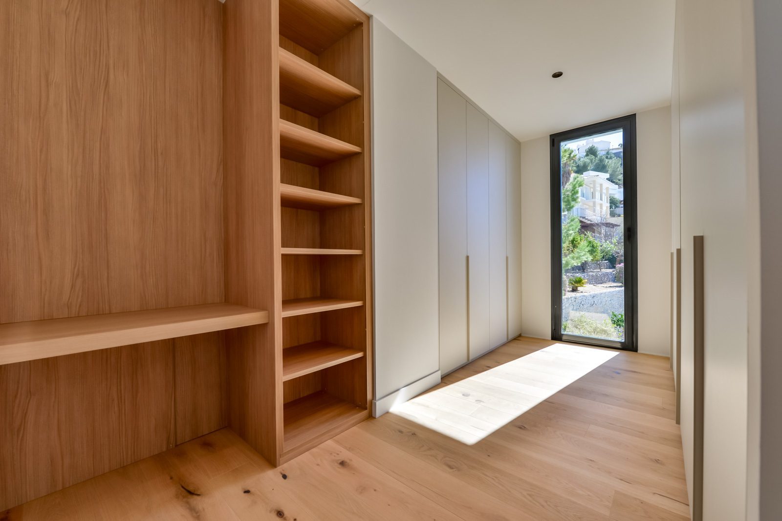 Custom-fitted dressing room with wooden shelving and built-in wardrobes in a 4-bedroom villa in Altea - The Estates