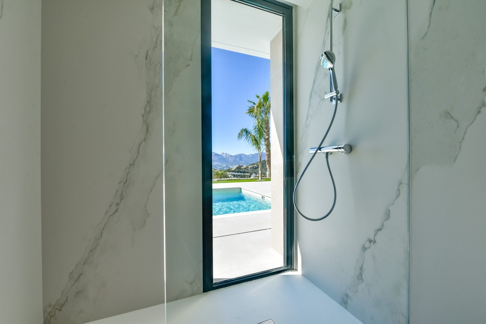 Marble shower room opening onto a pool and mountain views of a 4-bedroom villa in Altea - The Estates